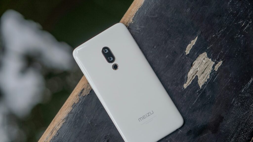 A white cell phone sitting on top of a wooden table