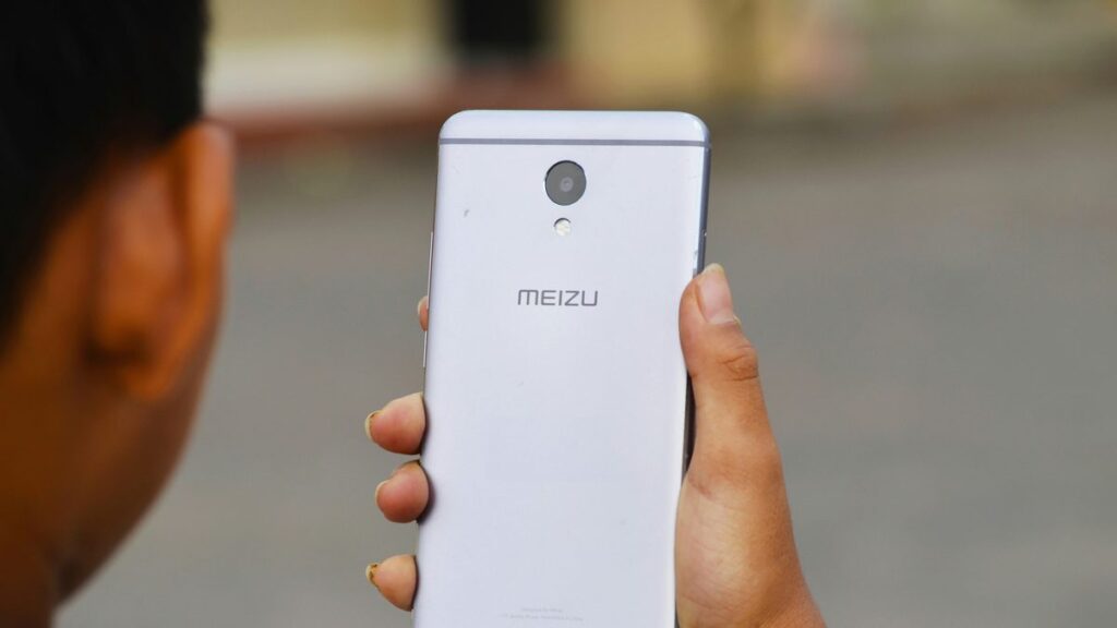 person holding silver Meizu Android smartphone