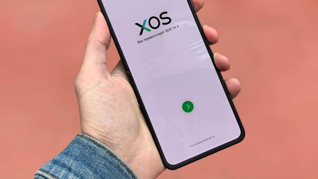 Close-up of a smartphone displaying the XOS 14.5 operating system interface in a hand.